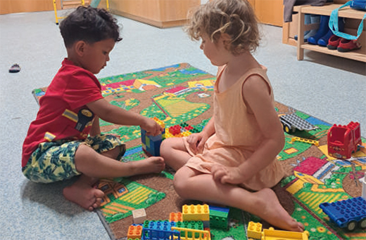 Betrifft Kinder, Spielende Kinder auf Spielteppich mit Bausteinen